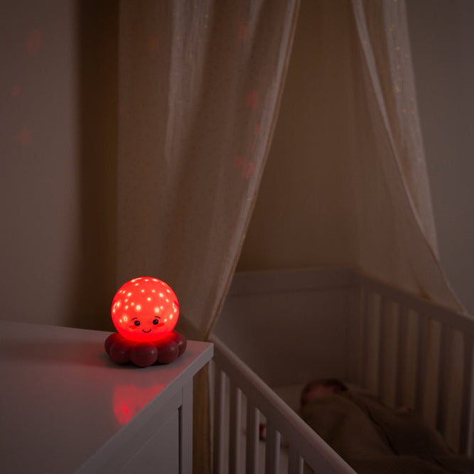 Red night light on a shelf with a crib in the background