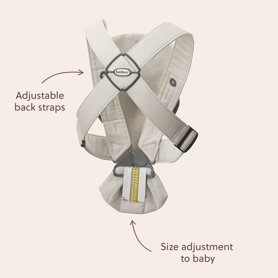 Baby carrier with adjustable back straps and size adjustment to baby on a light pink background