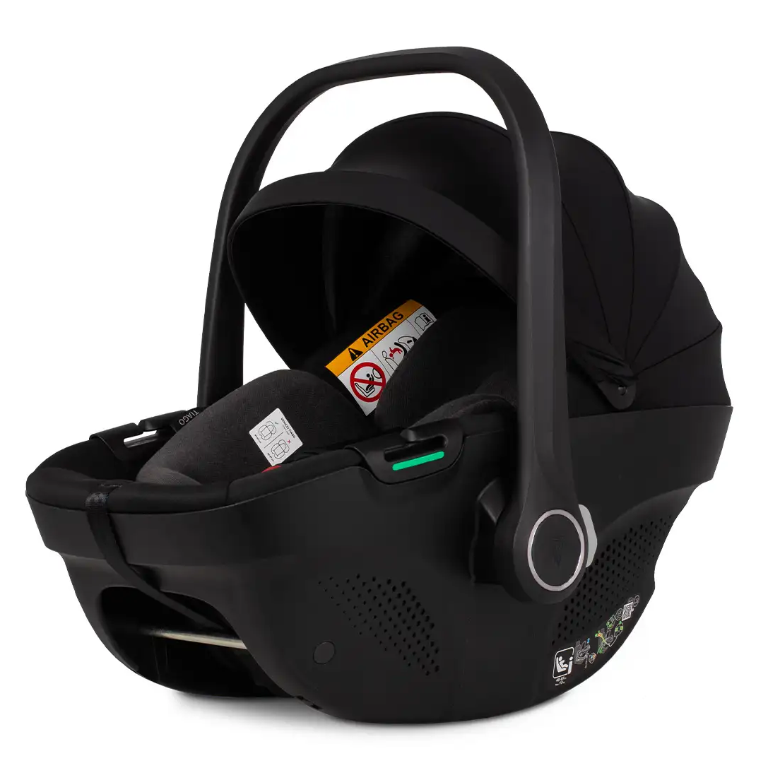 A black infant car seat with a matching black handle and harness, shown from a three-quarter angle on a solid white background.