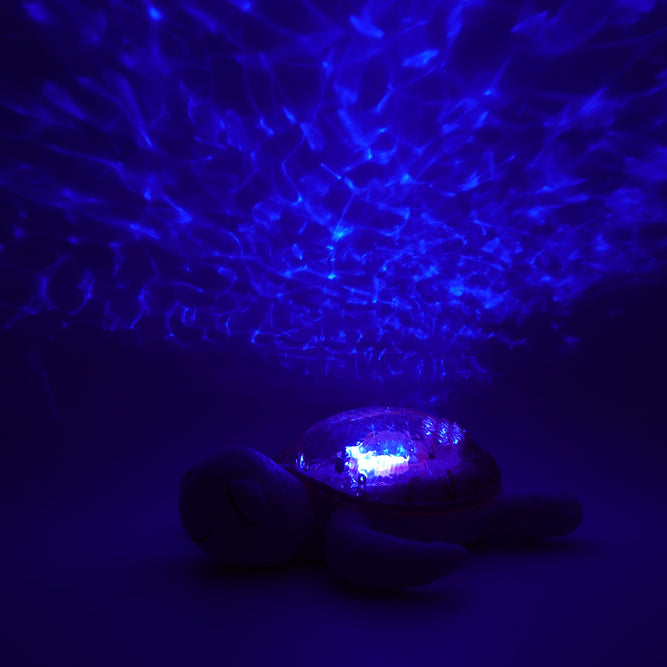 Blue light projector emitting a starry pattern on a dark background