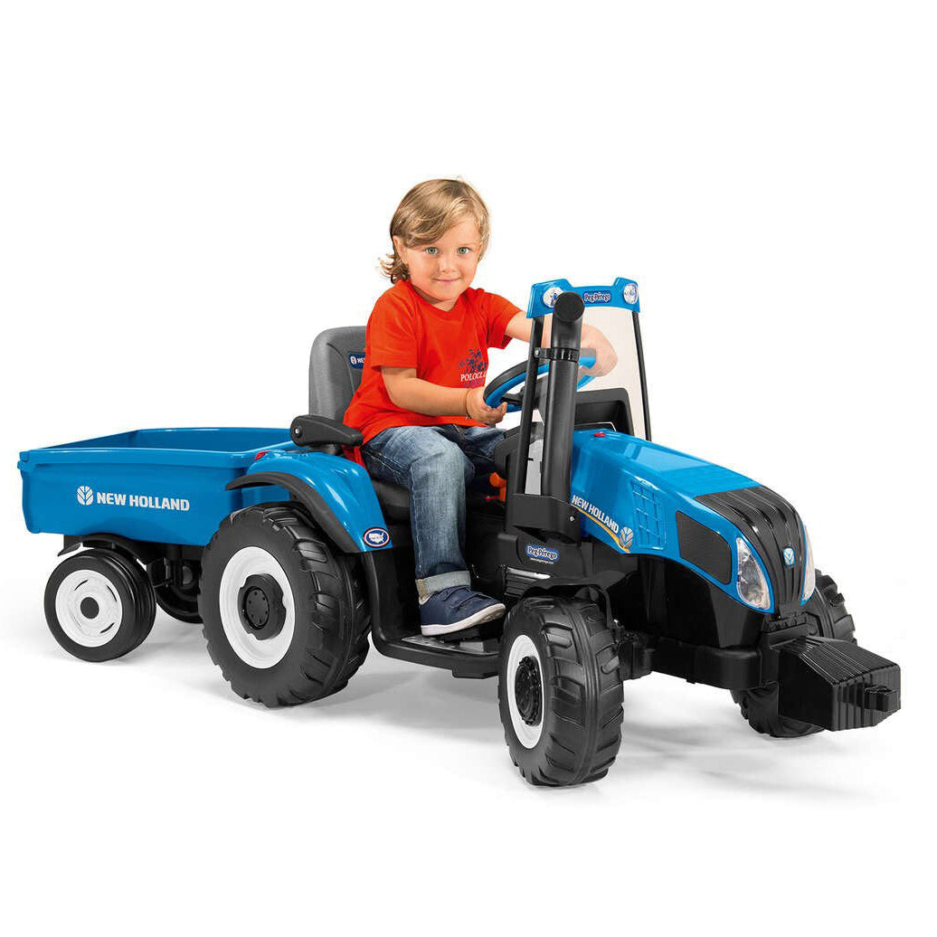 Child sitting on a blue toy tractor with a trailer, on a white background