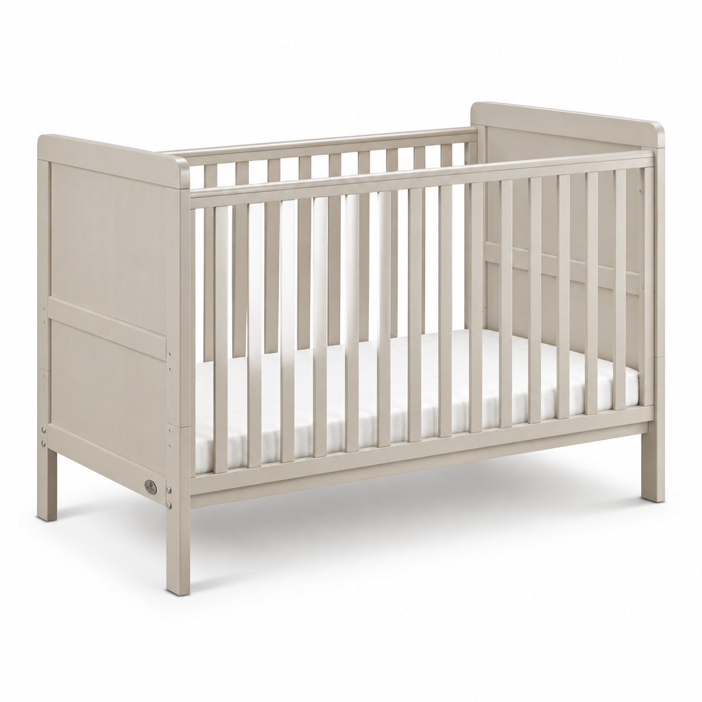 A light beige wooden convertible crib with vertical slats and a white mattress, shown on a clean white background.