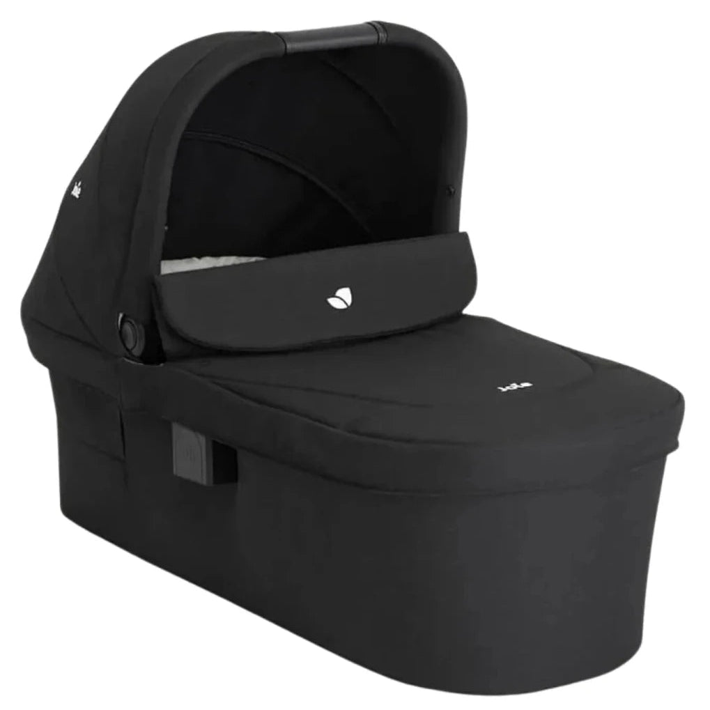 A black baby travel seat bassinet with an integrated canopy, shown at a three-quarter angle on a solid white background.