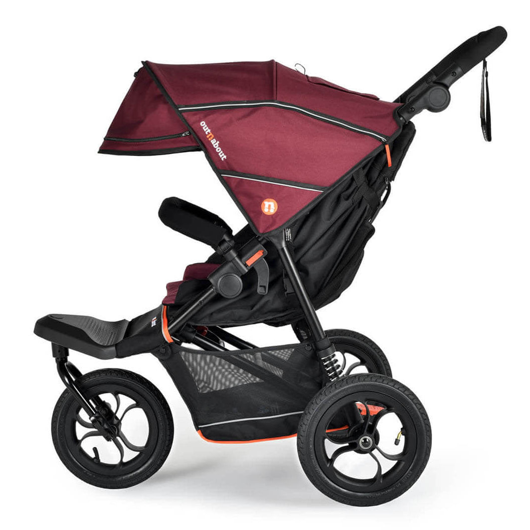 A stroller with a burgundy and black canopy, black frame, and three wheels, shown from a side profile on a white background.