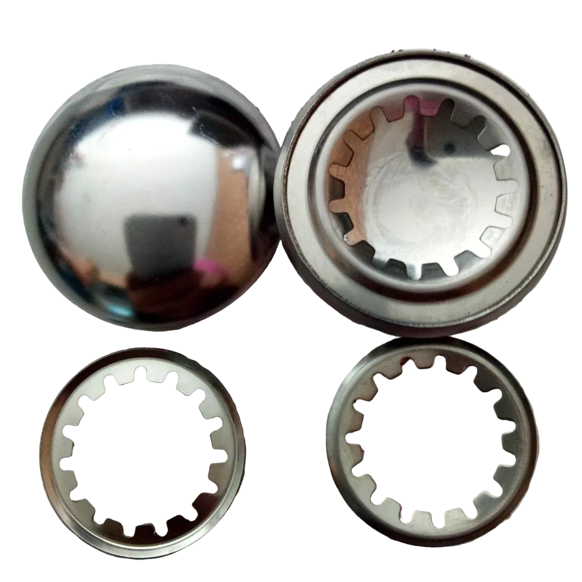 Four metallic circular components, including one polished dome-shaped piece and two ring-shaped pieces with internal gear-like cutouts, shown on a plain white background.