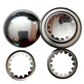 Four metallic circular components, including one polished dome-shaped piece and two ring-shaped pieces with internal gear-like cutouts, shown on a plain white background.