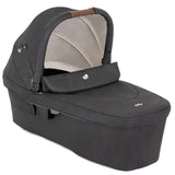 A dark gray baby bassinet and car seat travel system with a beige interior canopy lining and a brown handle, shown on a white background.