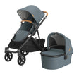 Gray stroller with canopy and bassinet on a white background