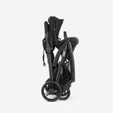 Black stroller folded and compact on a white background