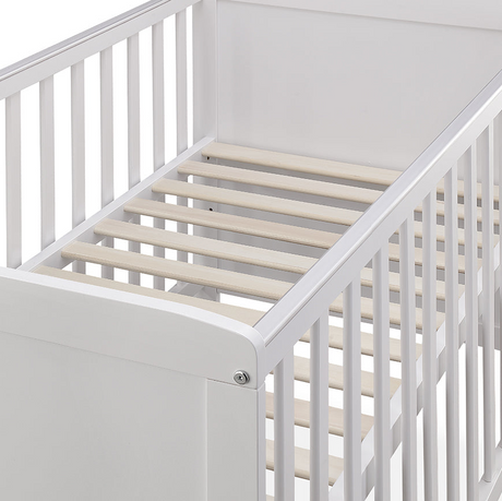 White crib with wooden slats on a white background
