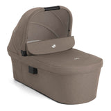 A baby bassinet in a taupe-brown fabric, shown with its canopy open and the lid folded down, on a clean white background.