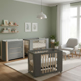 Nursery room with gray cribs, changing table, and decor elements.