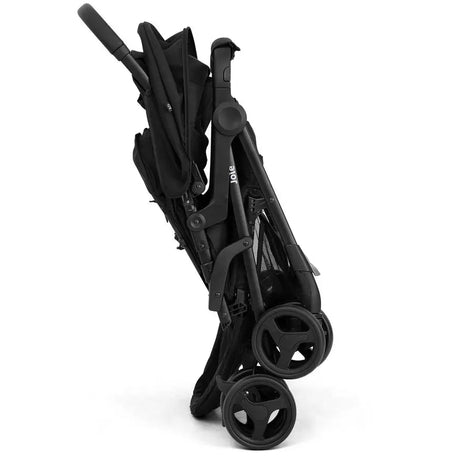 A black compact stroller folded into a slim, portable shape, shown from a side angle against a solid white background.