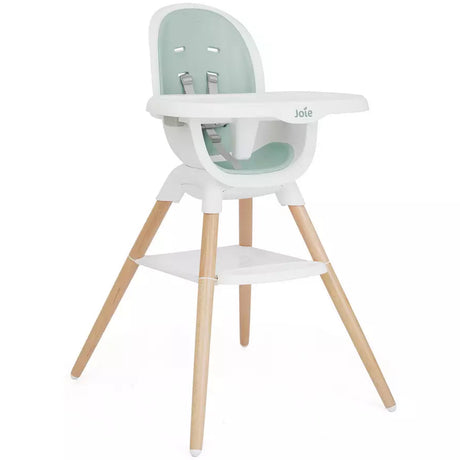A modern high chair with a white plastic seat and tray, a mint green padded backrest, and four natural wood legs, shown against a plain white background.