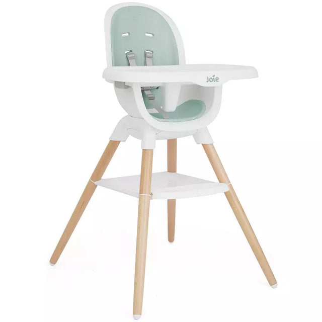 A modern high chair with a white plastic seat and tray, a mint green padded backrest, and four natural wood legs, shown against a plain white background.