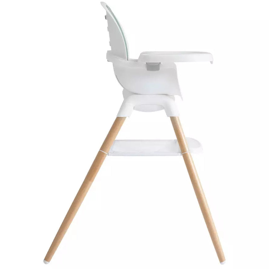A modern white baby high chair with light natural wood legs, shown from a side profile view against a solid white background.