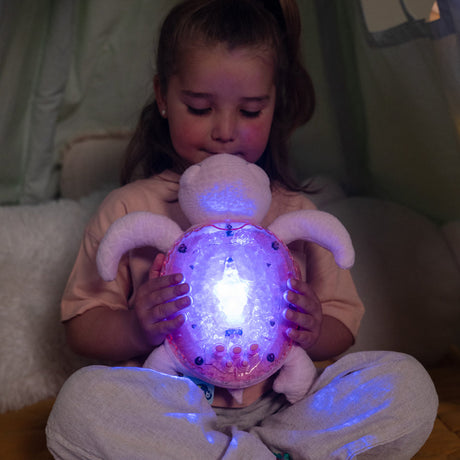 Child holding a glowing plush toy in a dimly lit room