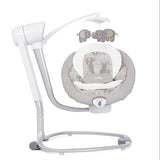 A Jojo baby swing and bassinet set in white and light gray, featuring a white adjustable support frame, a gray patterned bassinet cushion, and a gray elephant mobile hanging above.