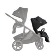 Gray stroller with black car seat attachment on a white background