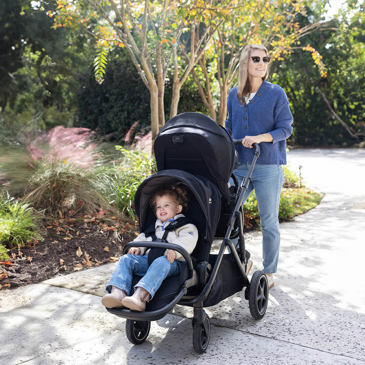 Woman pushing a stroller with a child in a park setting