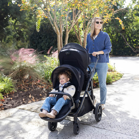 Woman pushing a stroller with a child in a park setting