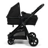 A black stroller and bassinet travel system on a clean white background. The stroller features a black bassinet, a black canopy, a black frame, and black wheels, with a gray mesh storage pocket on the lower basket.