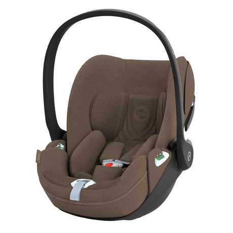 A baby car seat in a warm brown fabric with a black plastic base and handle, shown on a clean white background.