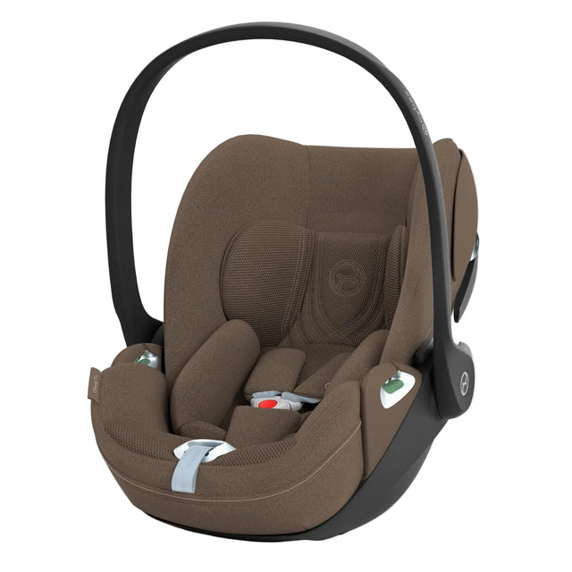 A baby car seat in a warm brown fabric with a black plastic base and handle, shown on a clean white background.
