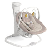A baby swing and bassinet seat with a beige and cream cushioned seat, white frame, and hanging leaf toys, shown on a plain white background.