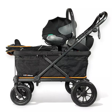 A black stroller travel system with a bassinet, infant car seat, and handle, featuring orange accent lines and a black storage bag, shown on a white background.