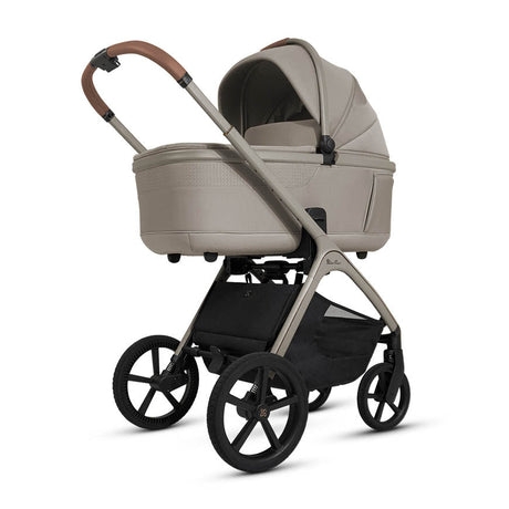 Beige baby stroller with black wheels on a white background