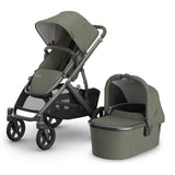 Gray stroller with attached bassinet on a white background